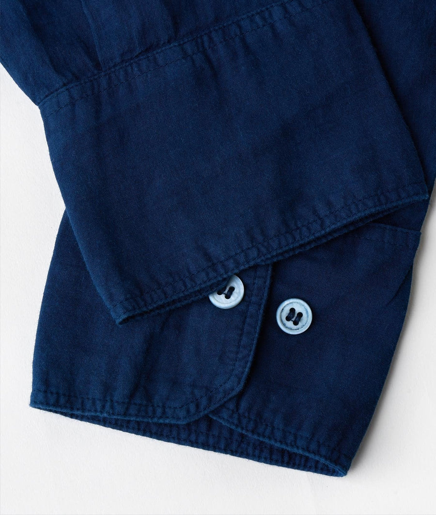 Navy blue pullover shirt with white buttons displayed in a close-up detail shot - Industry of All Nations