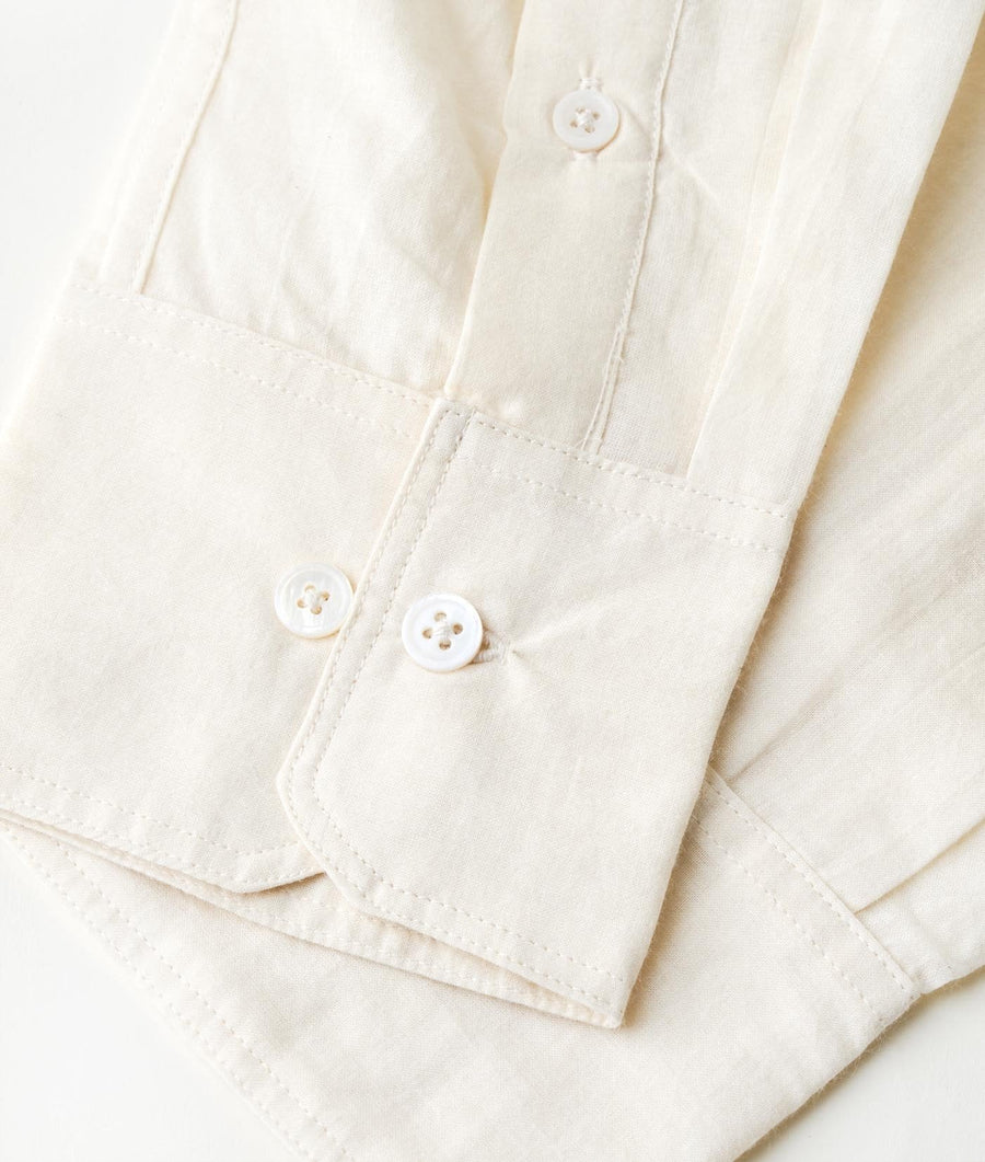Close-up detail of white cotton button-up shirt with four-hole buttons - Industry of All Nations