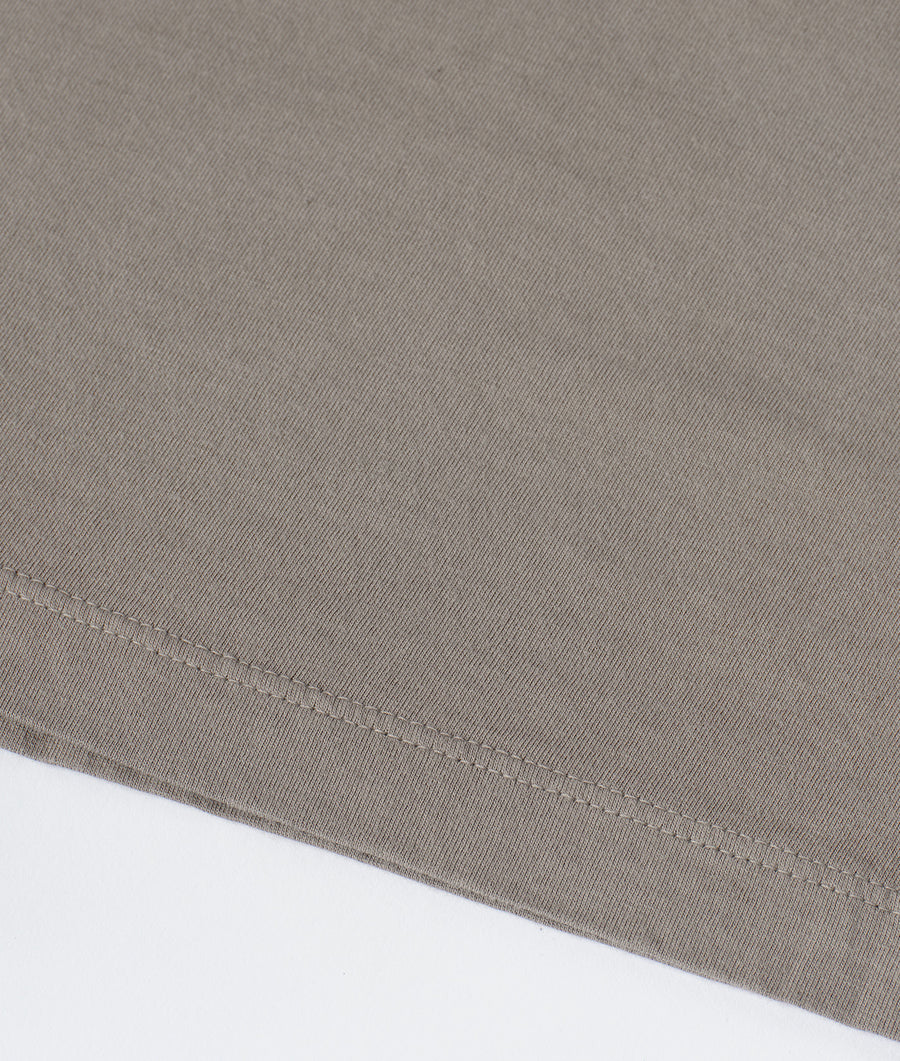 A close-up detail shot of a tan-colored organic cotton fabric with a tightly woven texture - Industry of All Nations