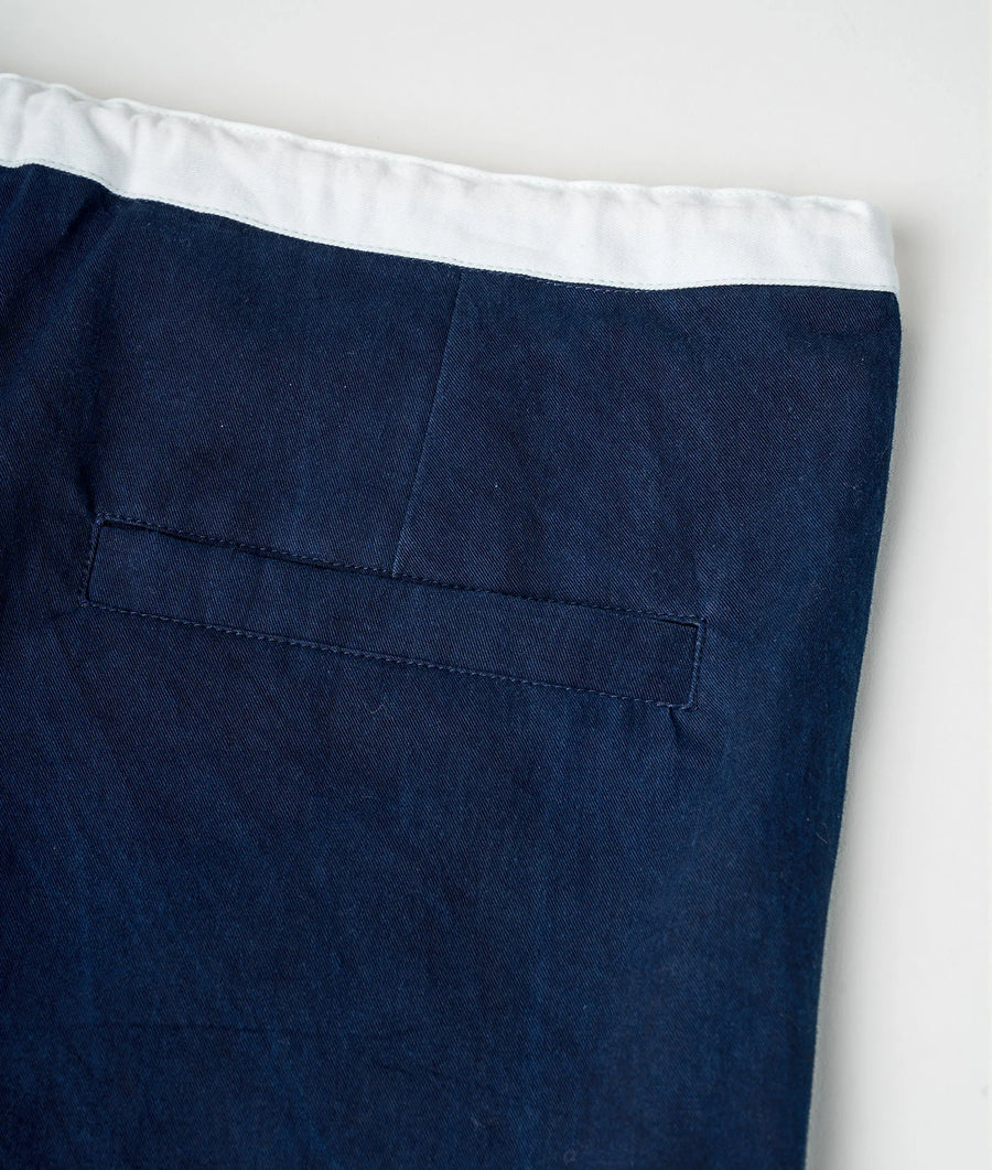 Detail shot of navy blue chino-style pants featuring a single side pocket - Industry of All Nations