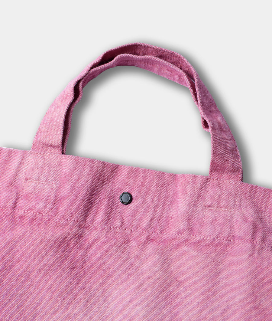 Flat lay of a pink reusable tote bag with a single black button detail - Industry of All Nations