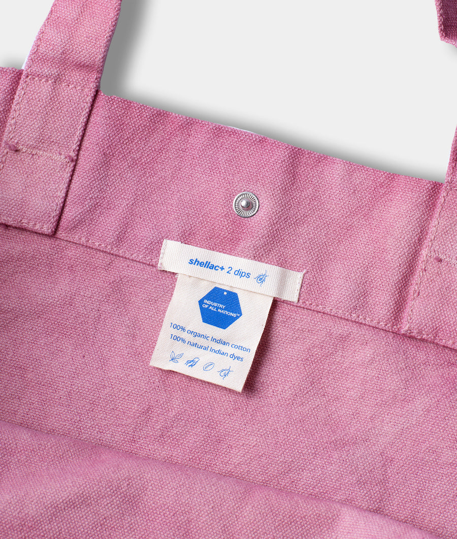 Detail shot of a vibrant pink organic cotton tote bag with "shellac + 2 dips" label - Industry of All Nations
