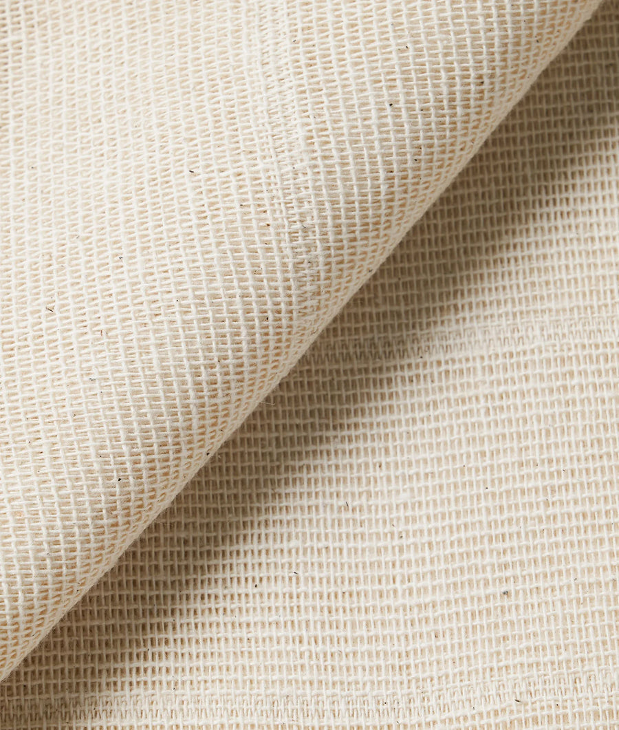 Detail shot of an organic cotton fabric with a textured, woven pattern in a natural off-white color - Industry of All Nations