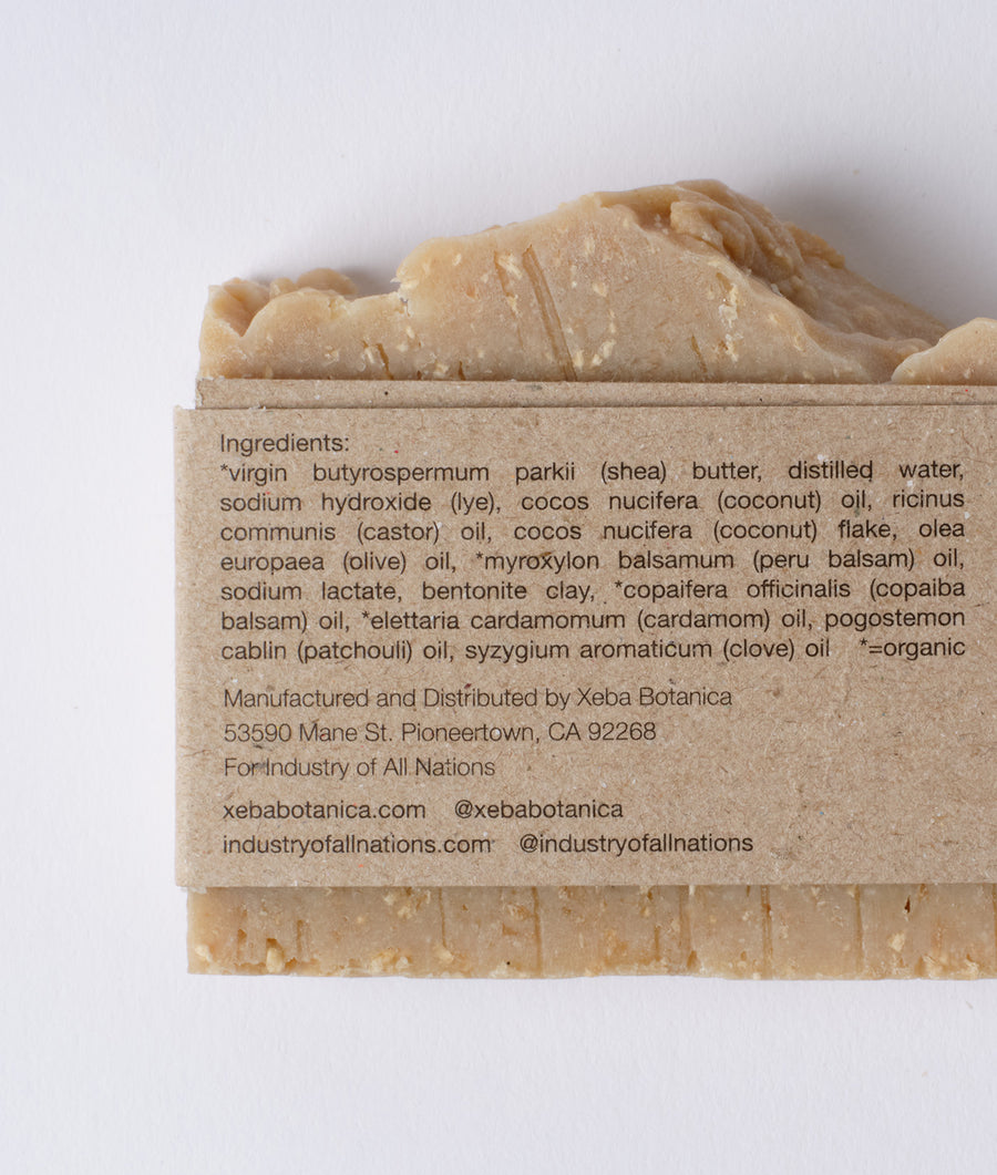 A close-up image showing the ingredients list on a bar of shea butter soap from the brand Industry of All Nations.