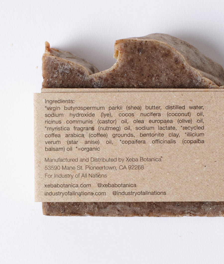 Flat lay image of a handcrafted bar of organic soap with a list of natural ingredients - Industry of All Nations