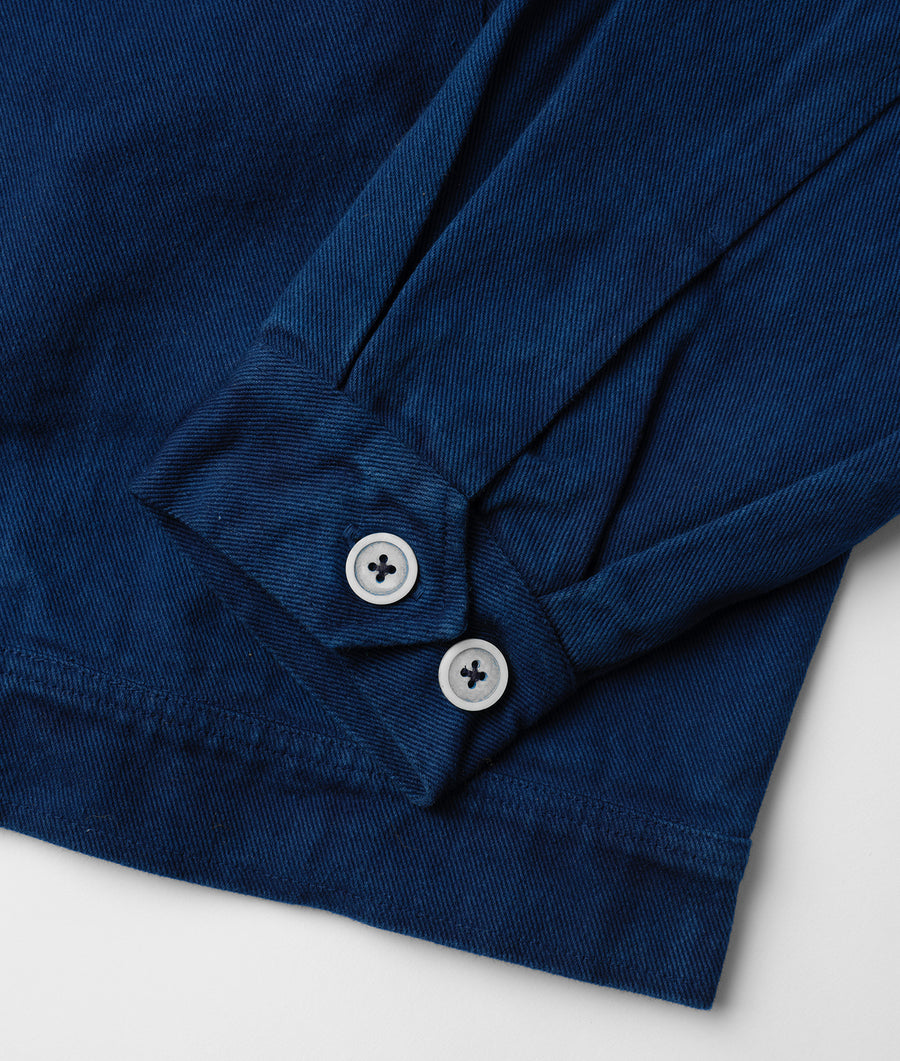 Navy blue button-down shirt with white buttons and textured fabric, displayed as a close-up detail shot - Industry of All Nations