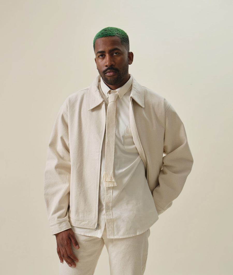 Beige cotton twill jacket worn by a model with green dyed hair - Industry of All Nations