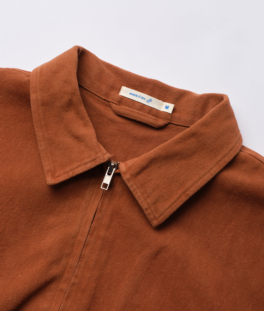 Brown corduroy shirt with collar, zipper closure, and fabric label displayed flat - Industry of All Nations