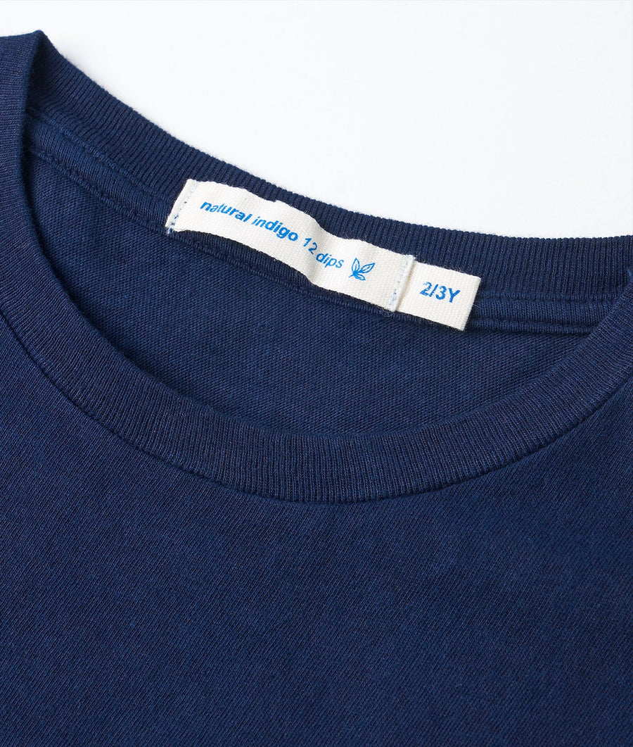 Close-up of a navy blue t-shirt with 'natural indigo 12 dips' label - Industry of All Nations