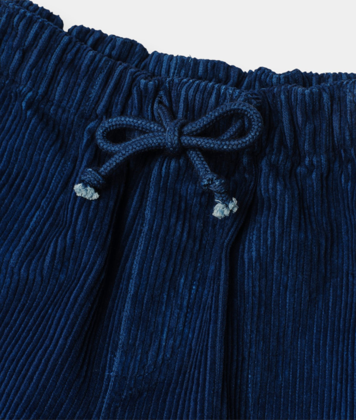 Elastic waistband and drawstring bow on Indigo 12 dyed corduroy kids pants - Industry of All Nations
