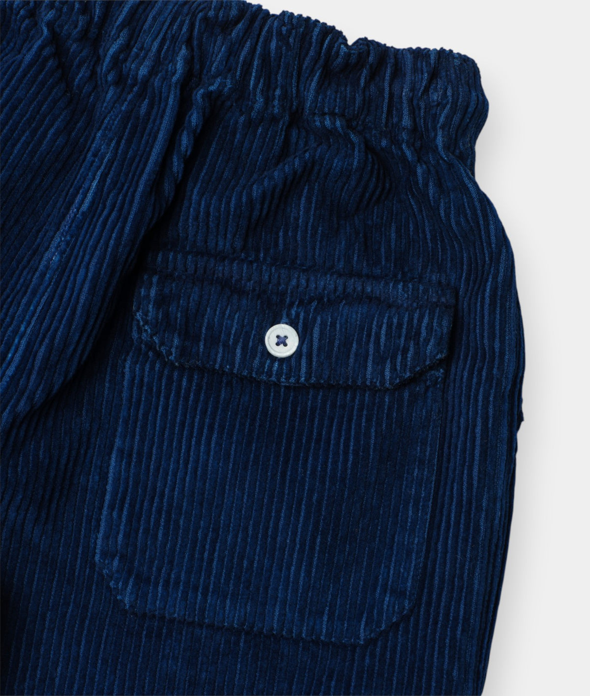 Close-up of blue corduroy pants with a pocket on a white background