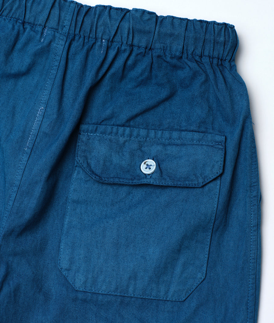 Flat lay detail shot of navy blue denim pants with a single button pocket - Industry of All Nations