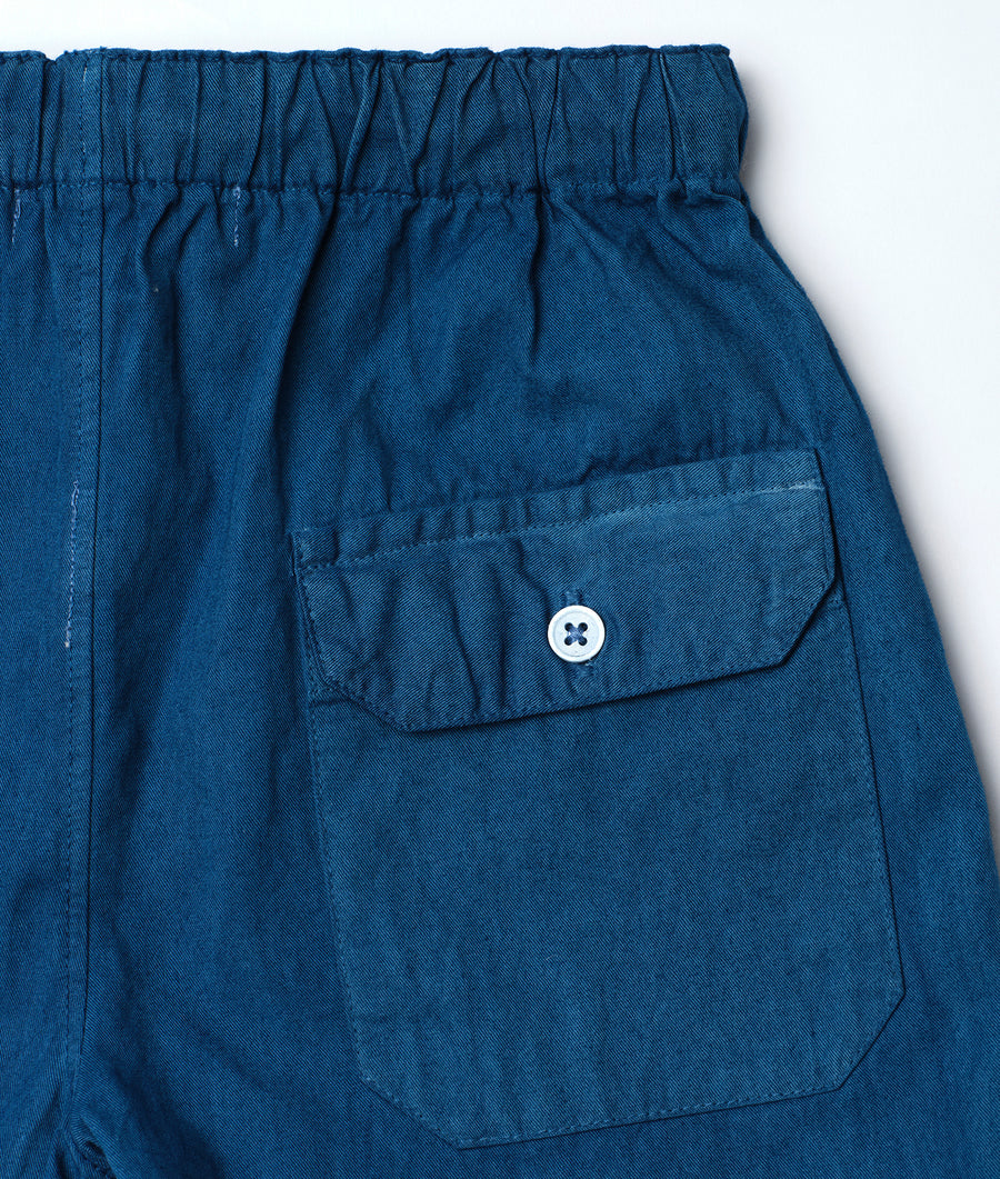 Blue cotton shorts with a drawstring waistband and a small pocket, displayed in a flat lay - Industry of All Nations