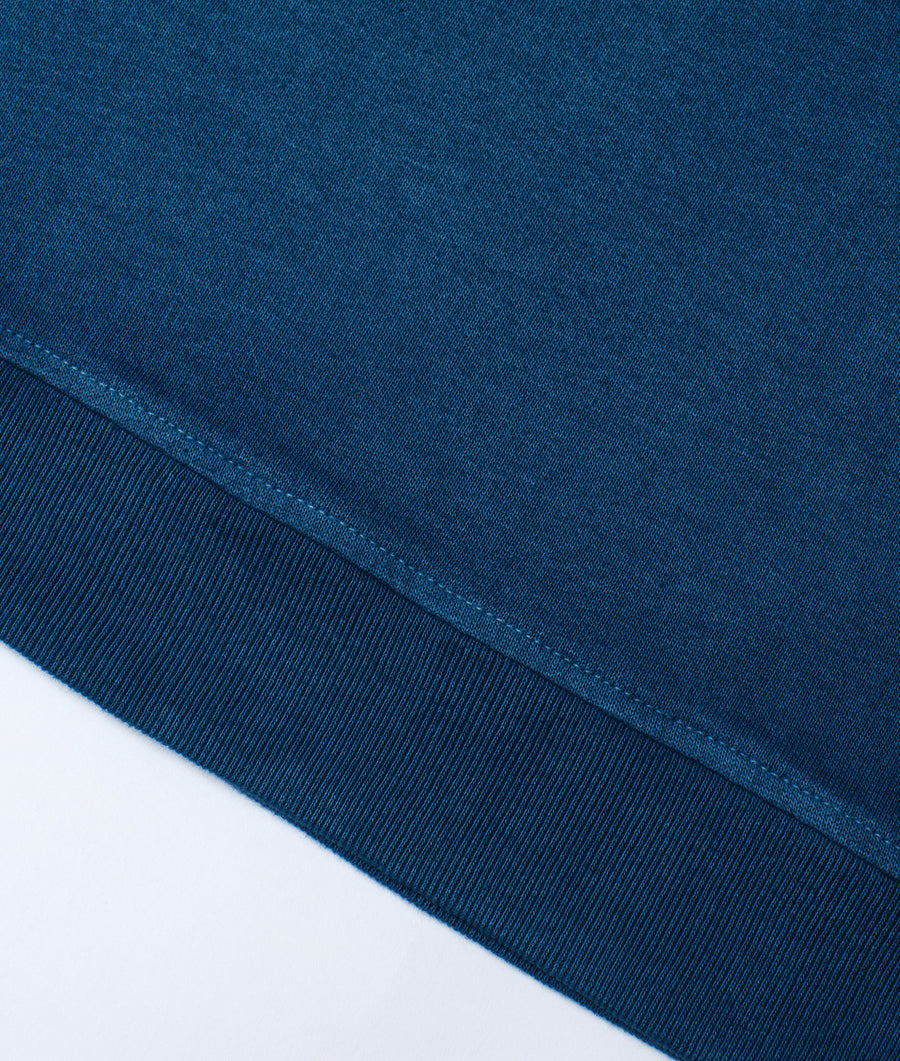 Close-up detail shot of a dark blue organic cotton garment with stitched seam details - Industry of All Nations