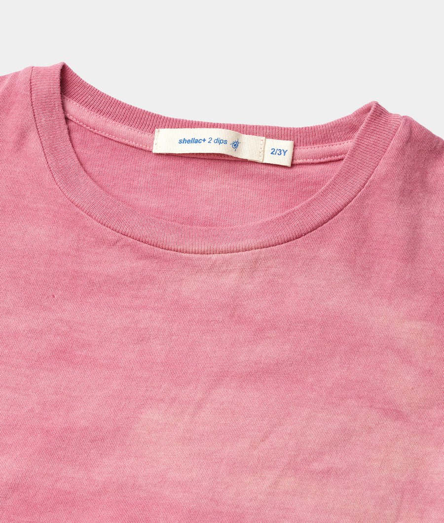 Close-up detail shot of a pink organic cotton t-shirt with a Shellac+ 2 dips label - Industry of All Nations