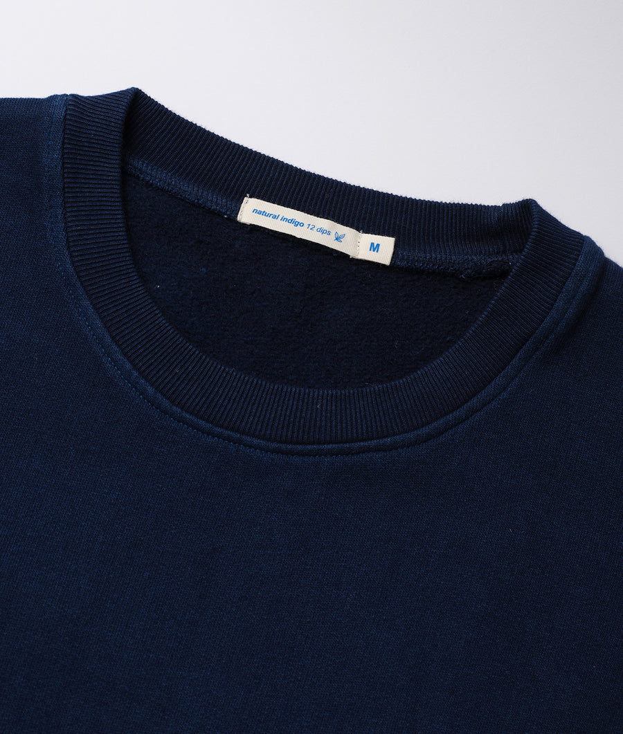 Closeup of a navy blue organic cotton crewneck sweater with a Natural Indigo tag - Industry of All Nations