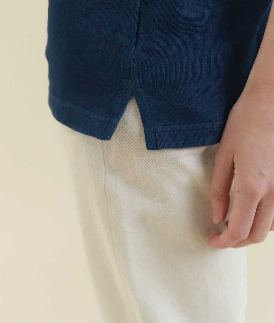 Detail shot of a navy blue ribbed knit sweater from Industry of All Nations.