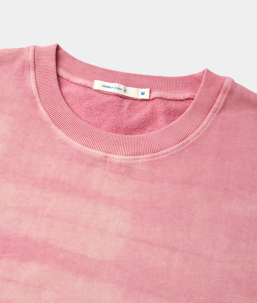 A close-up detail shot of a pink ribbed knit sweater or sweatshirt from Industry of All Nations.