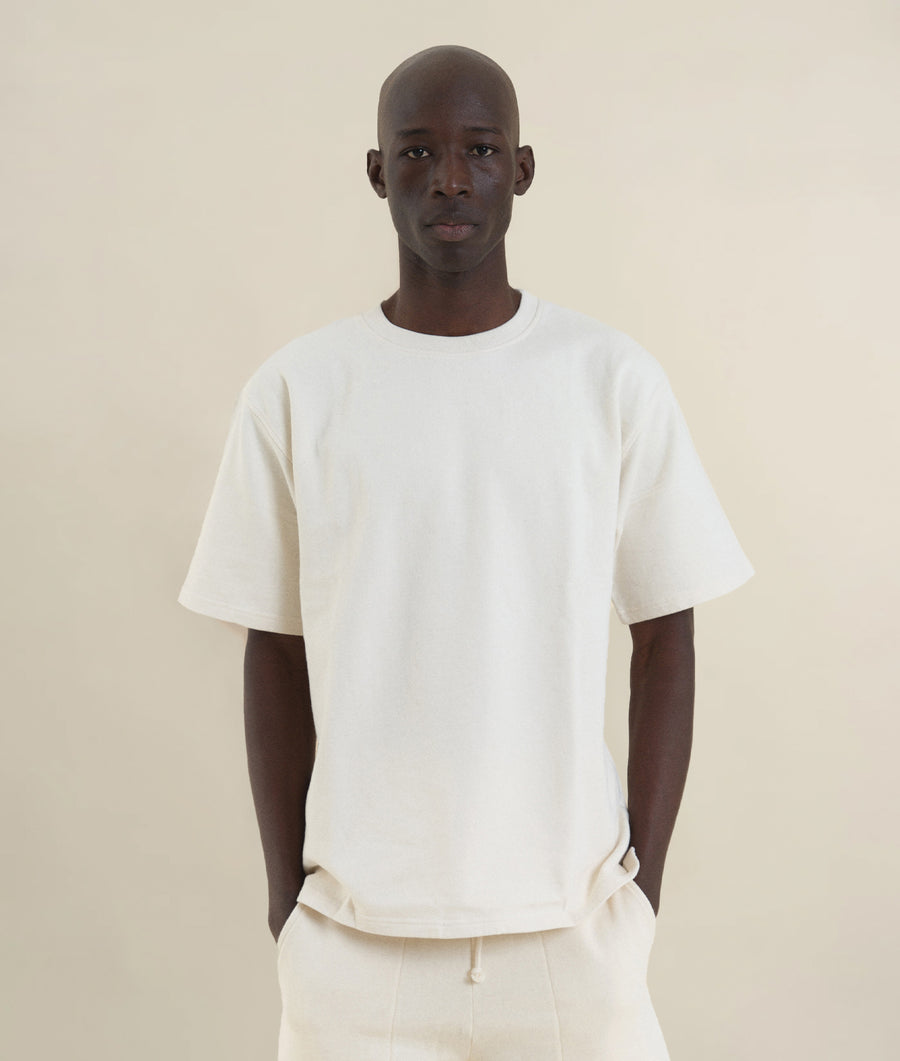A man wearing a plain white t-shirt against a light background - Industry of All Nations