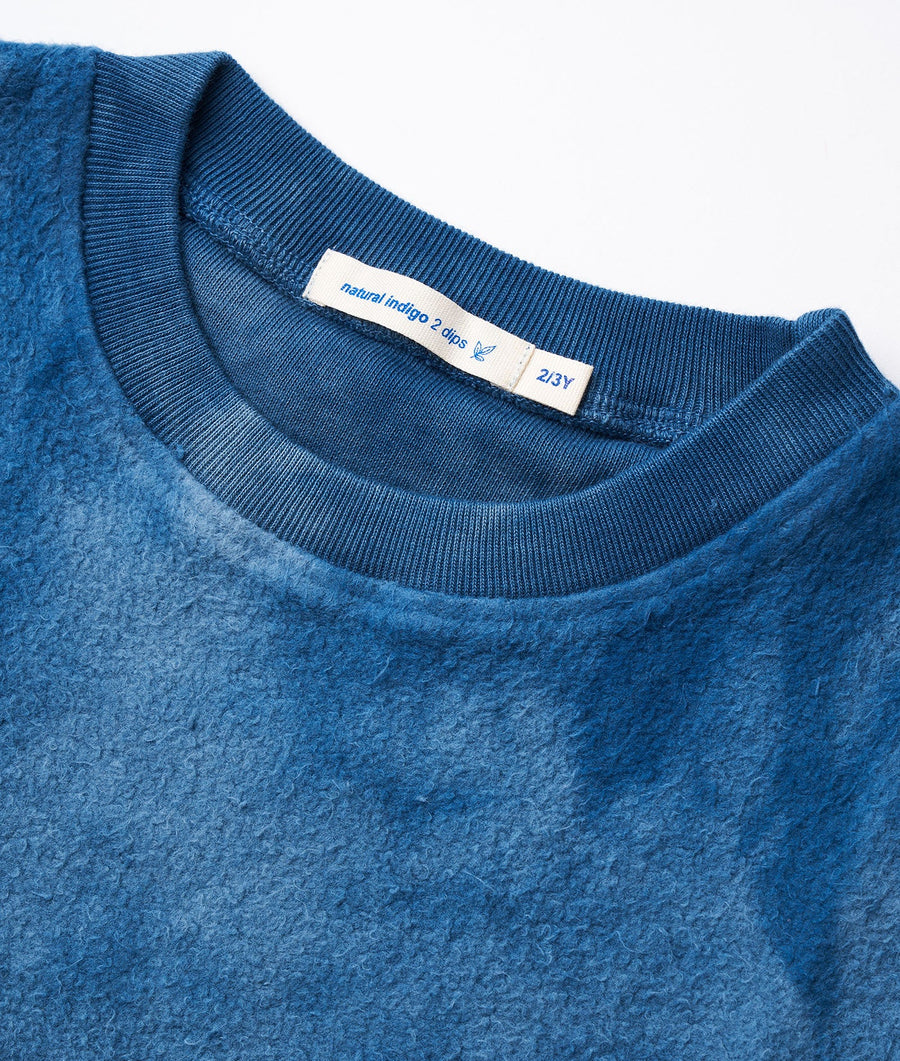 Closeup detail shot of a blue knit sweater with Natural Indigo 2 dye label - Industry of All Nations
