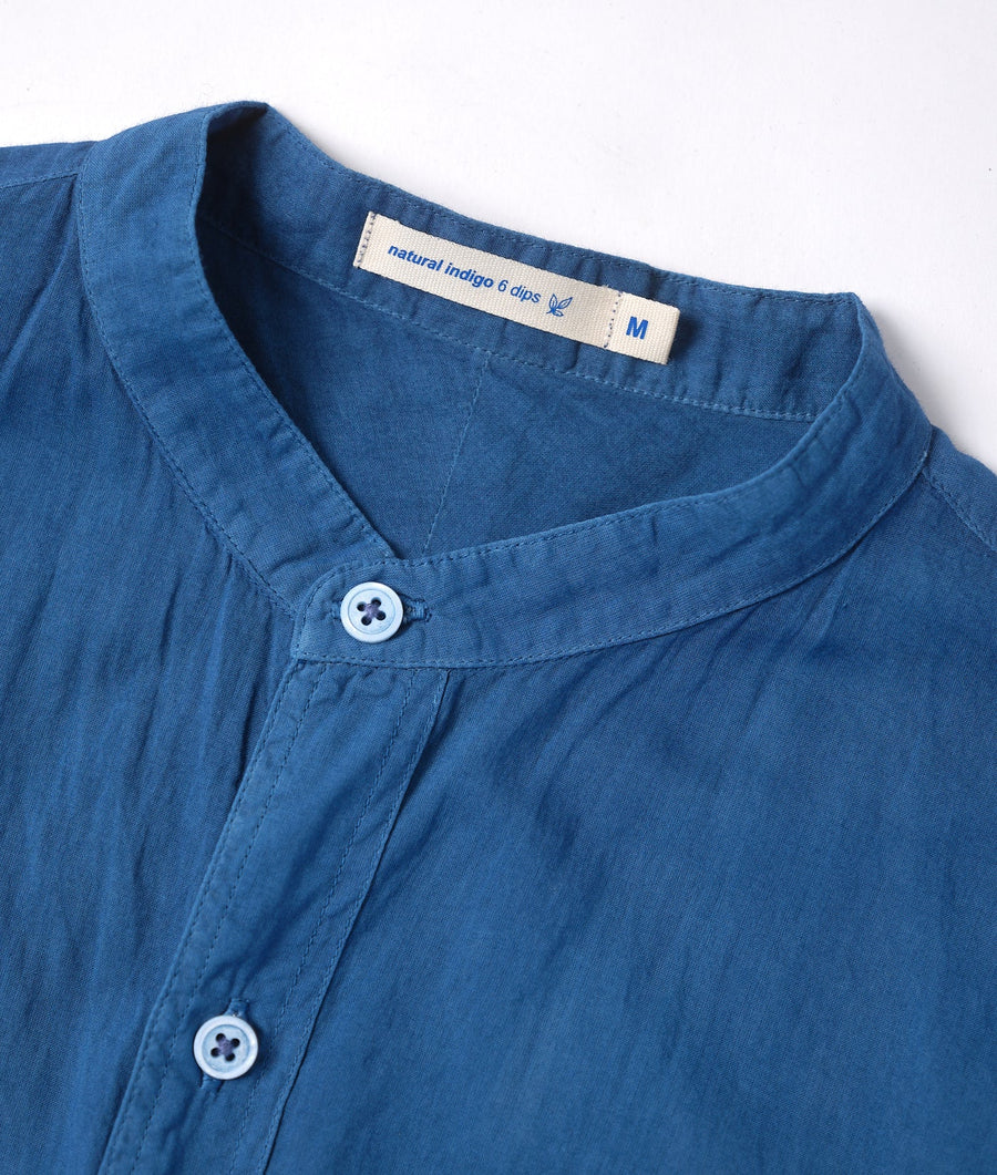 A close-up detail shot of a navy blue, naturally dyed button-up shirt from Industry of All Nations.