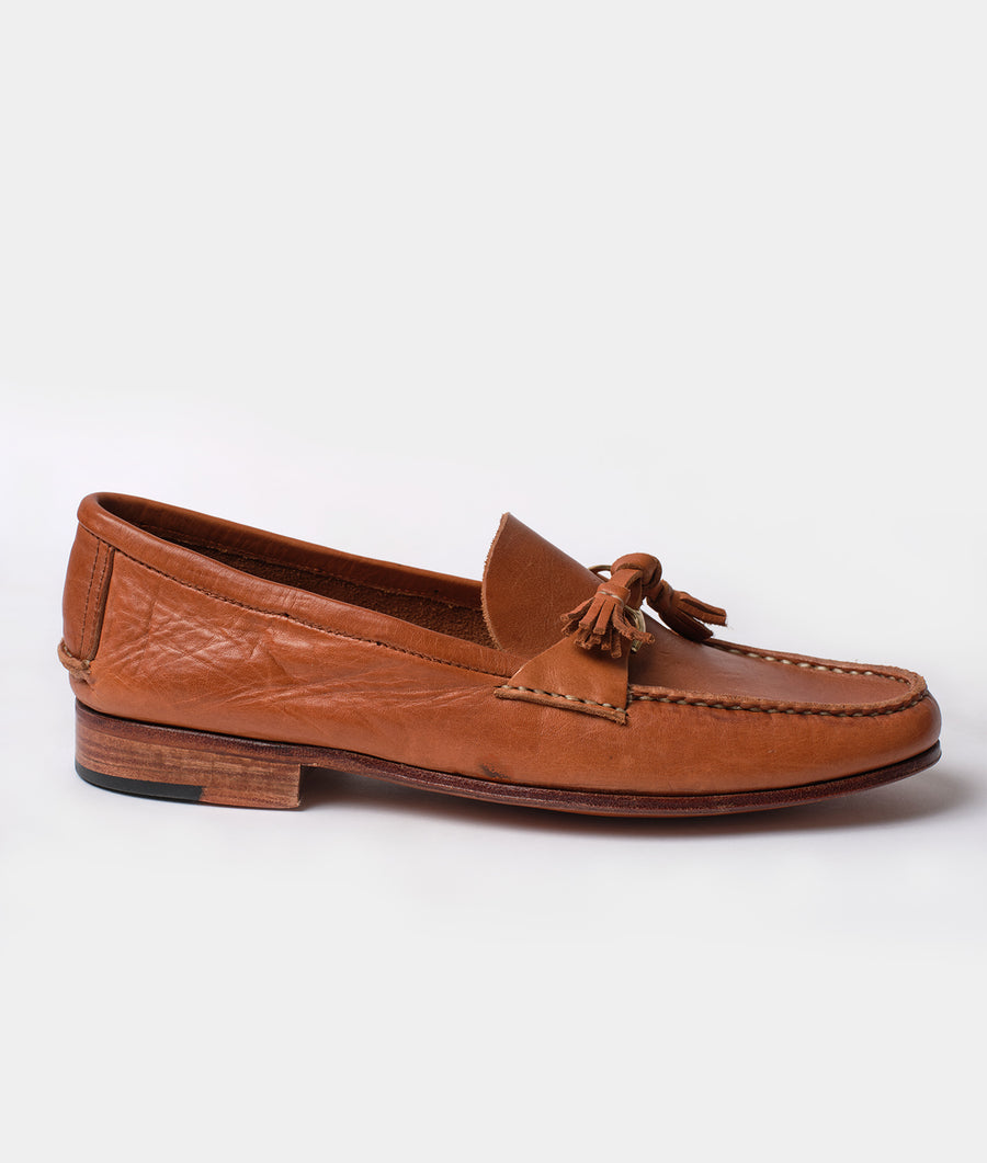 Tan leather loafers with tassels displayed on a plain background - Industry of All Nations