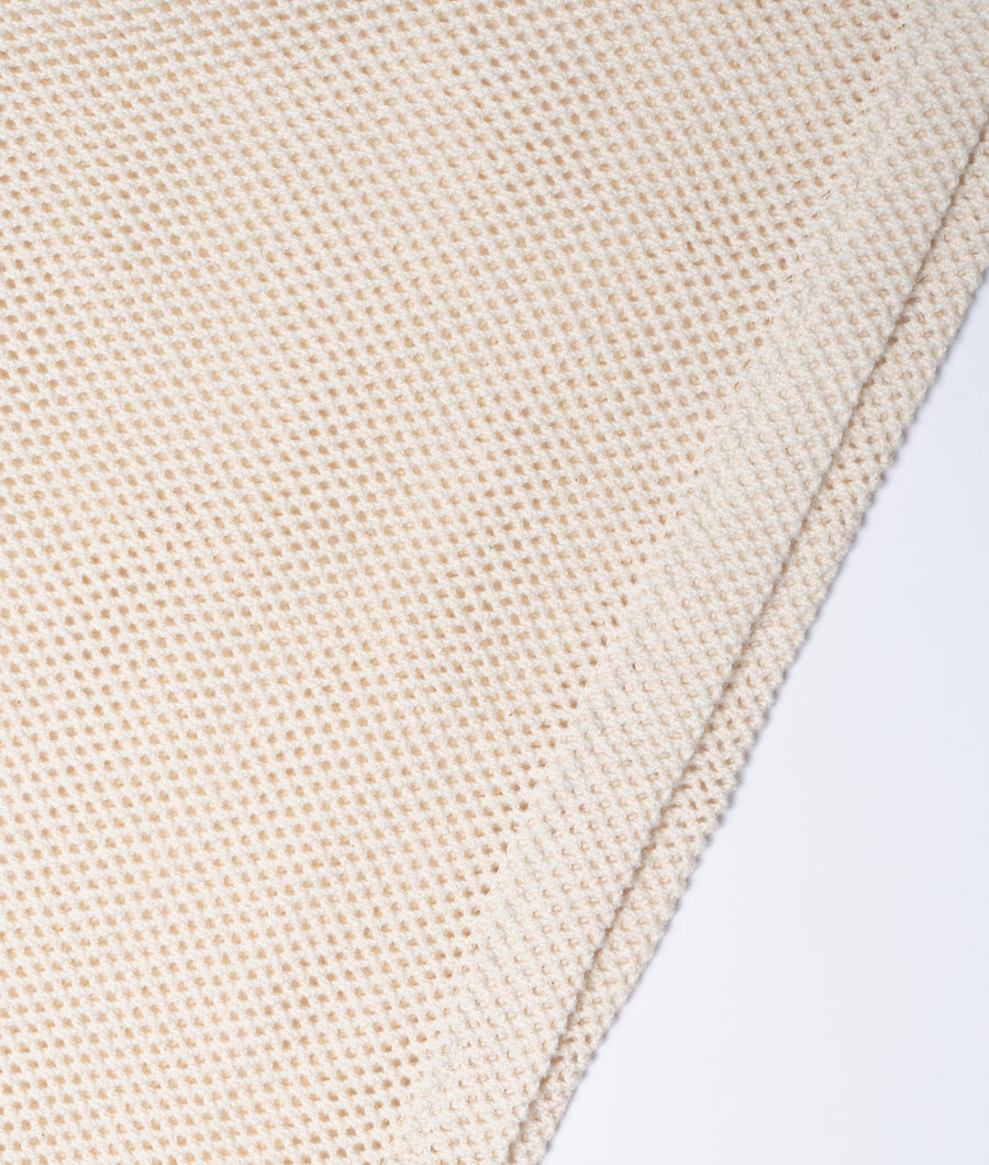 Detail shot of a cream-colored organic cotton knit fabric with a textured waffle pattern - Industry of All Nations