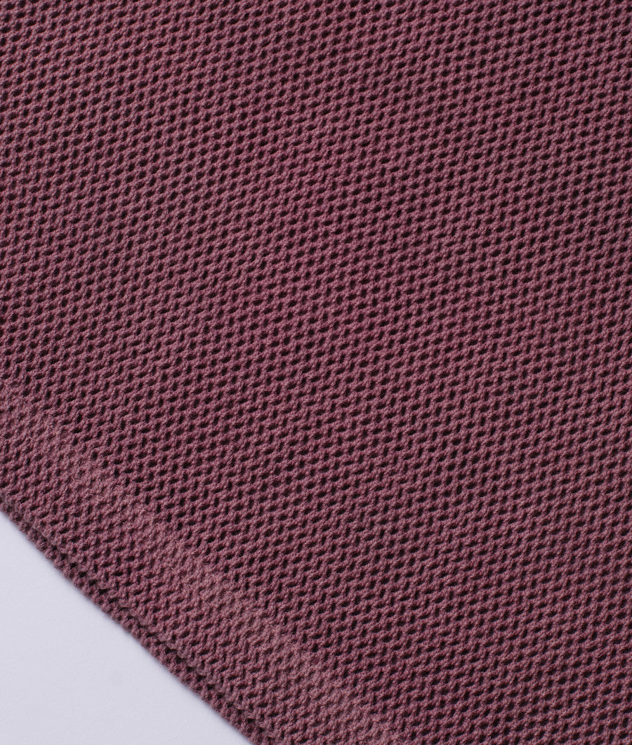 Close-up of a pink knitted fabric swatch with a textured honeycomb pattern - Industry of All Nations