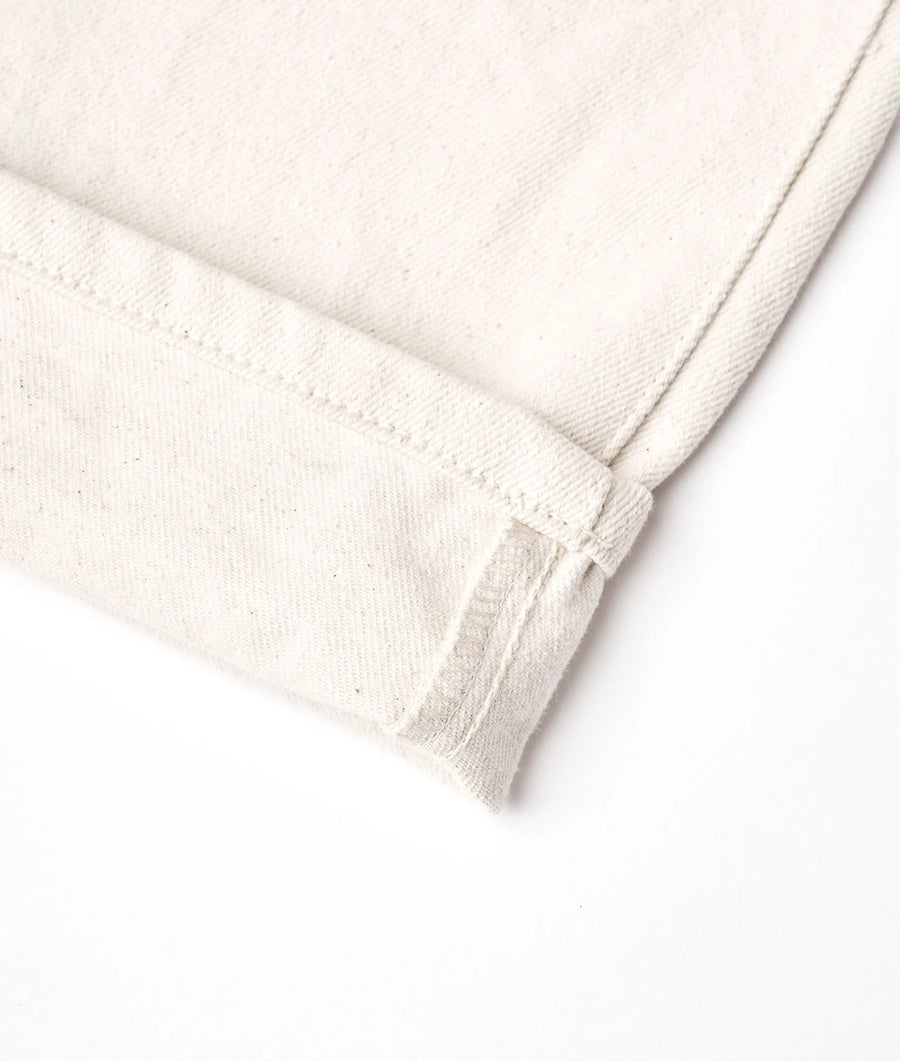 Close-up image of a white cotton fabric in a folded and creased state, displaying the soft and organic texture of the material - Industry of All Nations