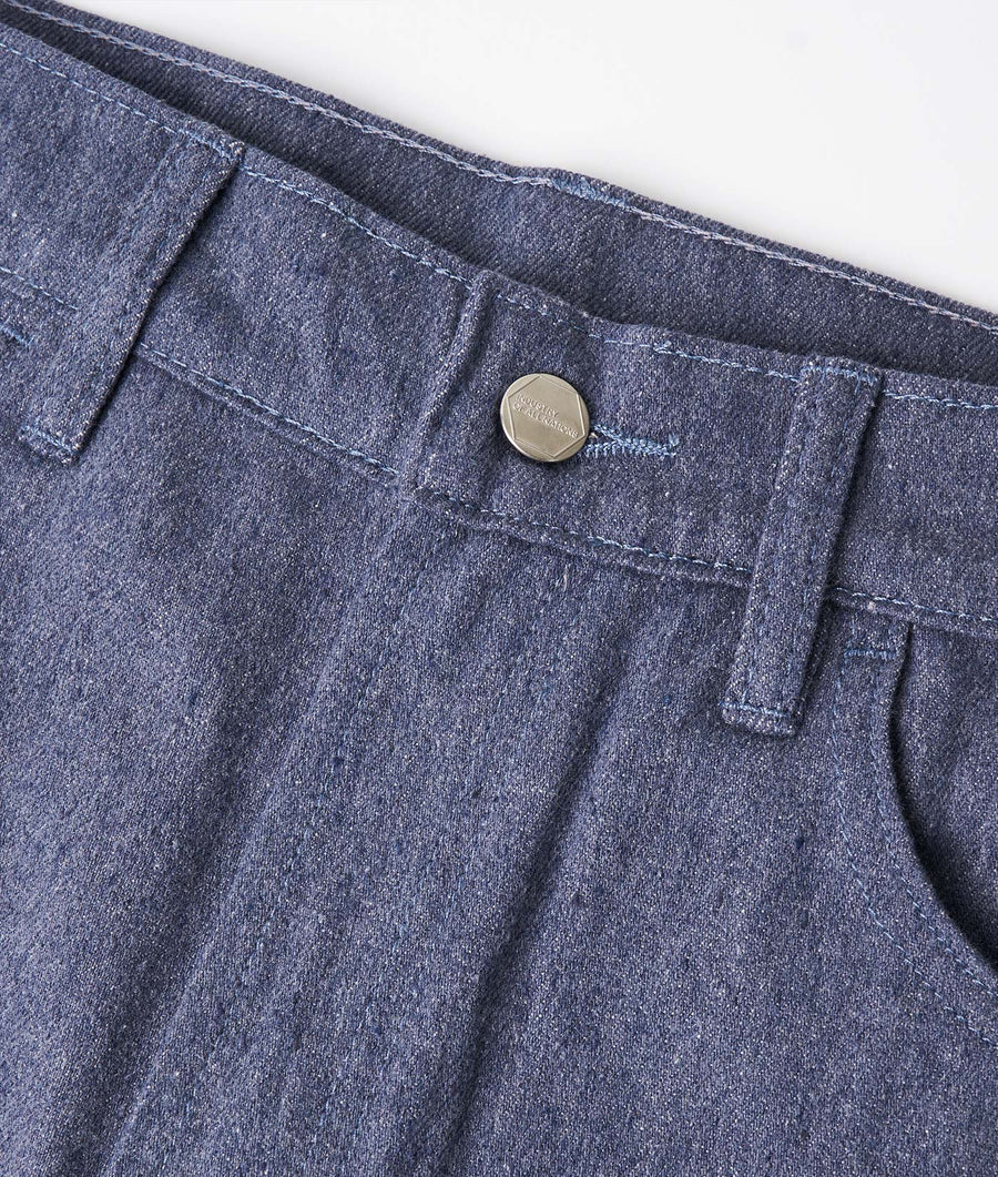 Close-up detail shot of dark denim pants with metal button closure - Industry of All Nations
