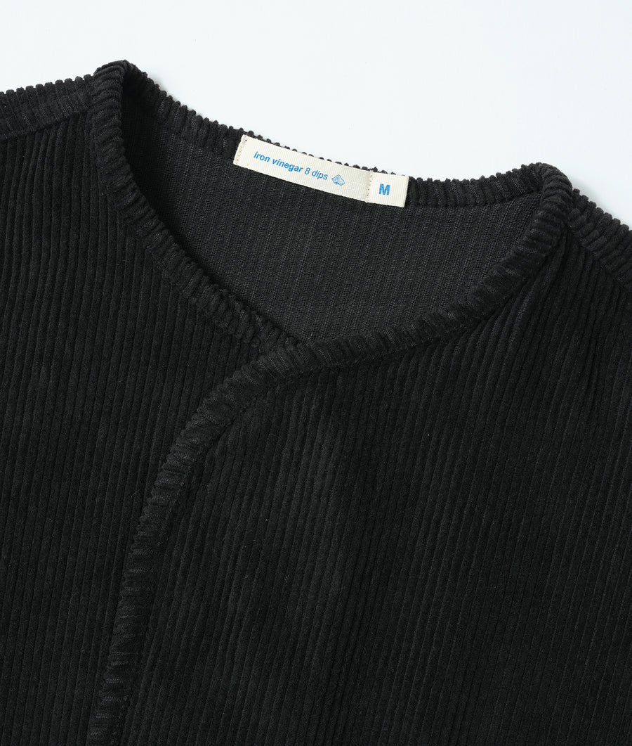 Detail shot of a black ribbed cotton knit garment with an Industry of All Nations label - Industry of All Nations