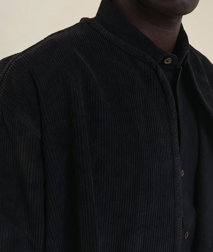 Close-up of black pleated organic cotton jacket worn by model - Industry of All Nations
