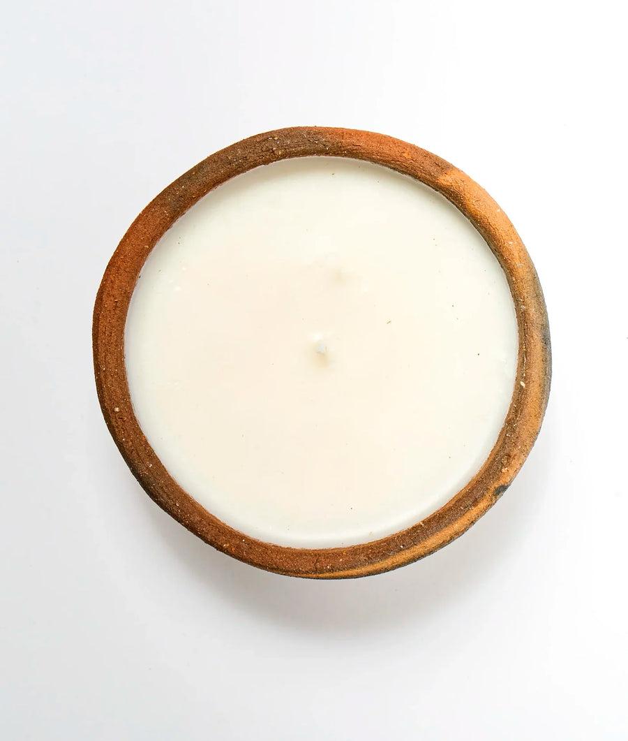 Overhead view of a round, cream-colored dessert or pudding in a brown ceramic bowl - Industry of All Nations