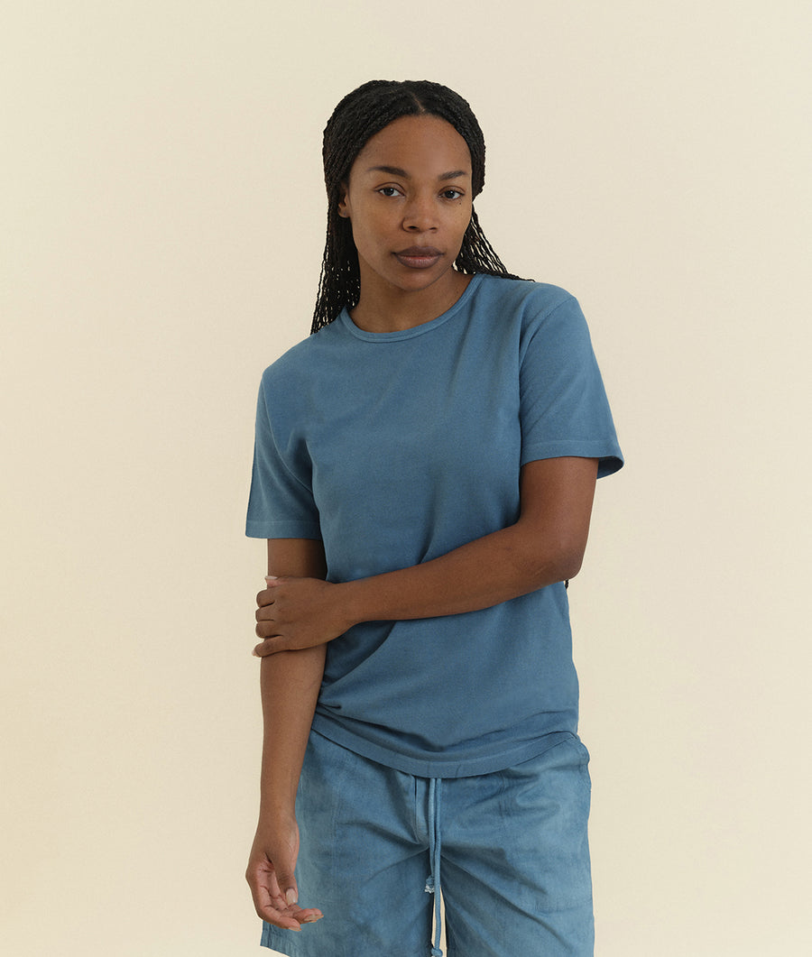 Woman wearing a blue t-shirt from Industry of All Nations