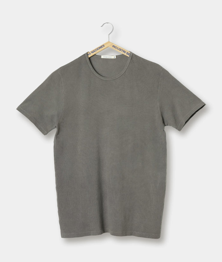 A grey crewneck t-shirt made from organic cotton pique, hanging on a hanger against a white background.