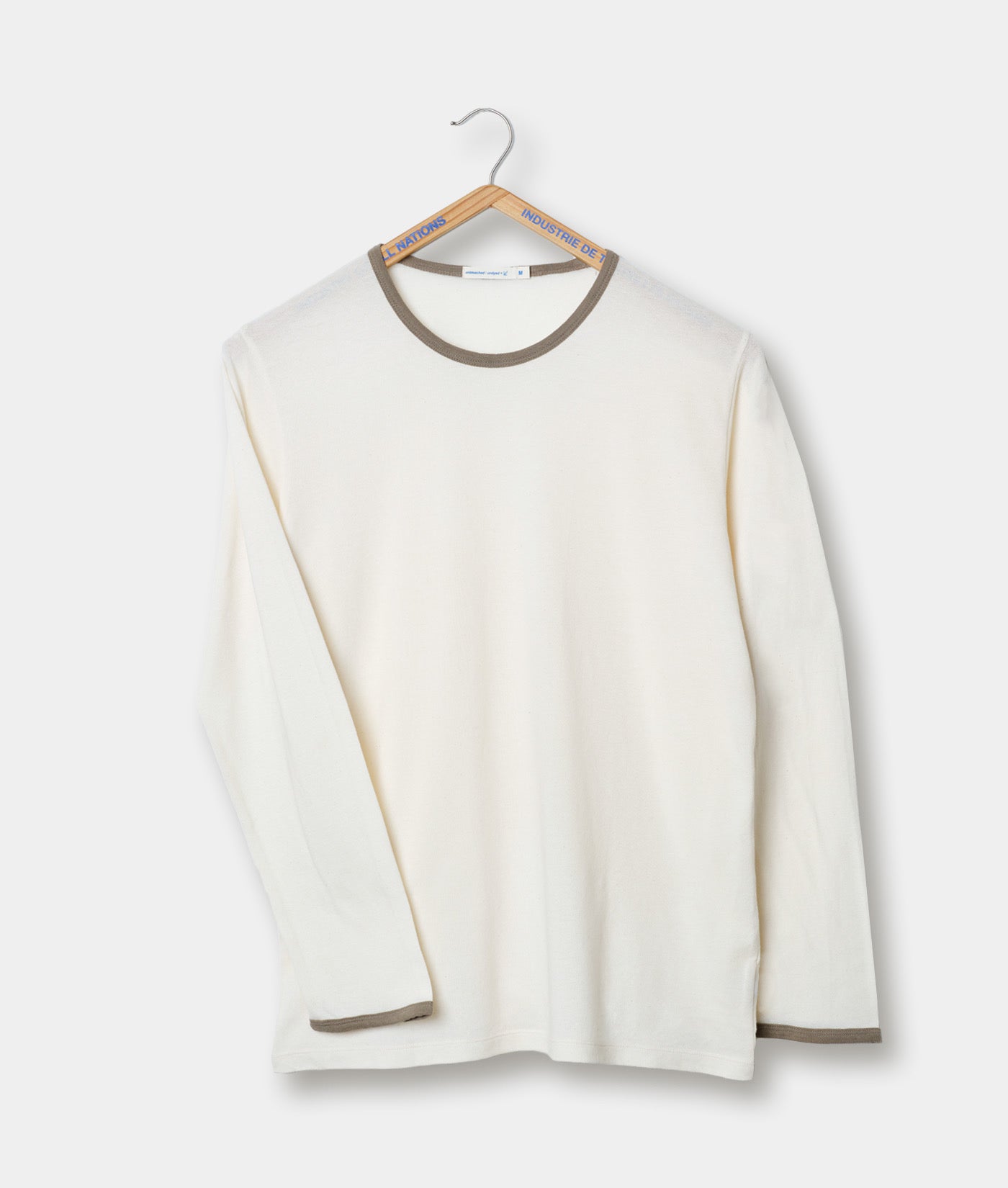 White long sleeve t-shirt with grey trim on a hanger against a white background