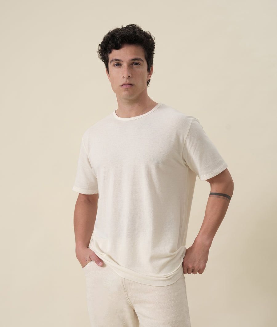 A male model wearing a white t-shirt in a minimalist studio shot - Industry of All Nations