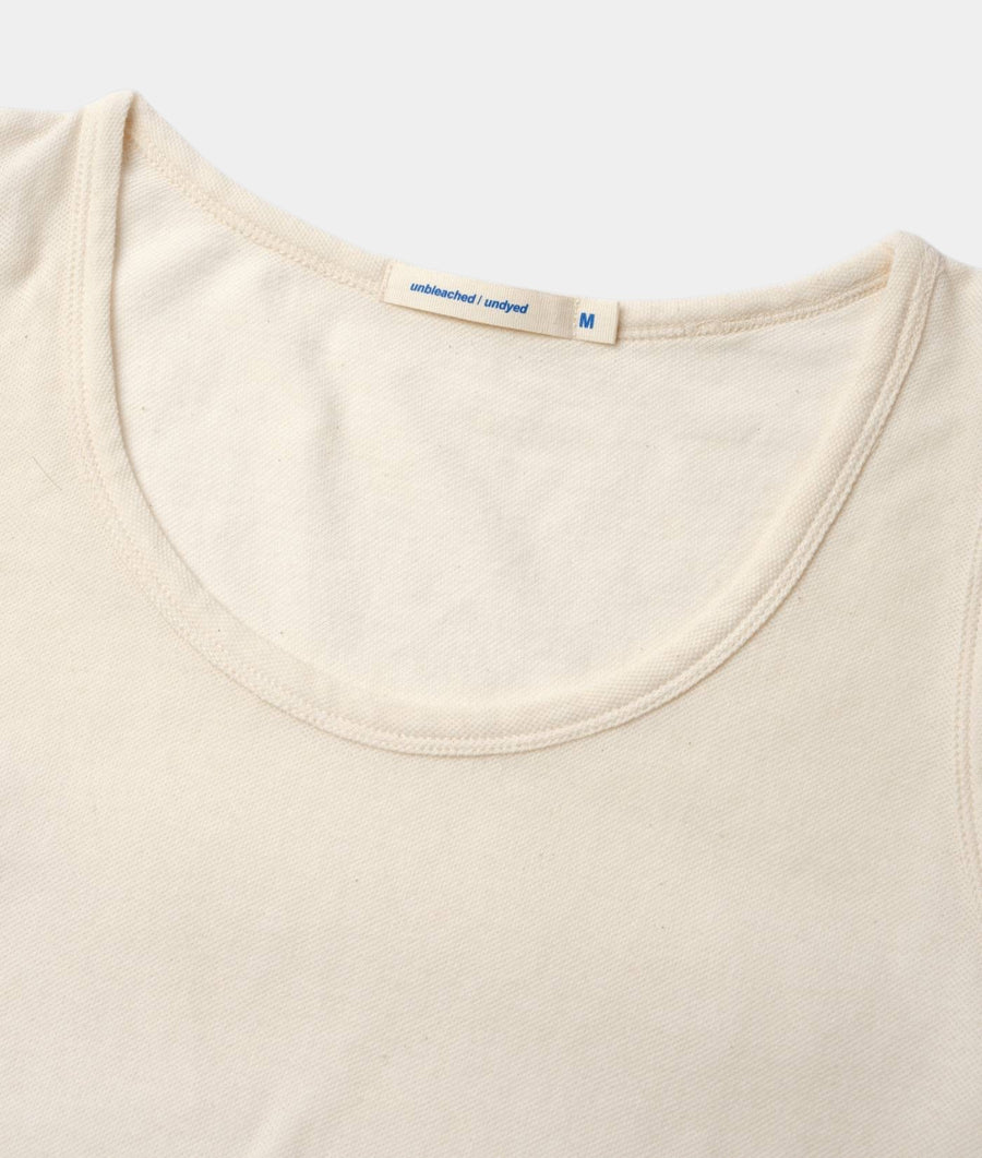 Flat lay of an unbleached, undyed cotton t-shirt with a medium size tag - Industry of All Nations