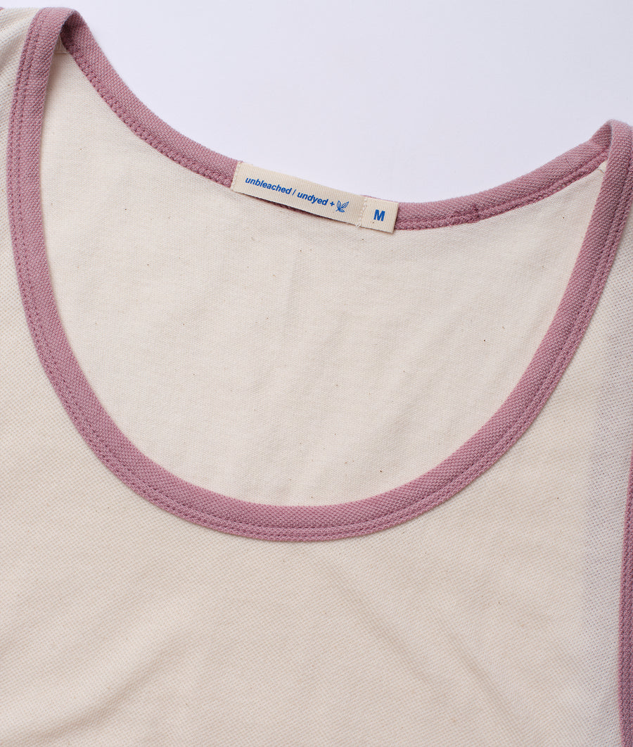 A closeup detail shot of the neckline of a natural-colored cotton tank top with pink trim - Industry of All Nations