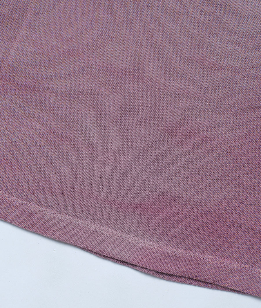 A close-up, flat lay image of a mauve-colored, organic cotton fabric with a ribbed texture - Industry of All Nations.