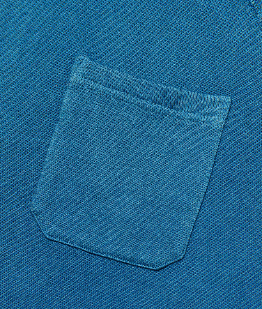 Detail shot of a blue cotton t-shirt with a small pocket on the front - Industry of All Nations