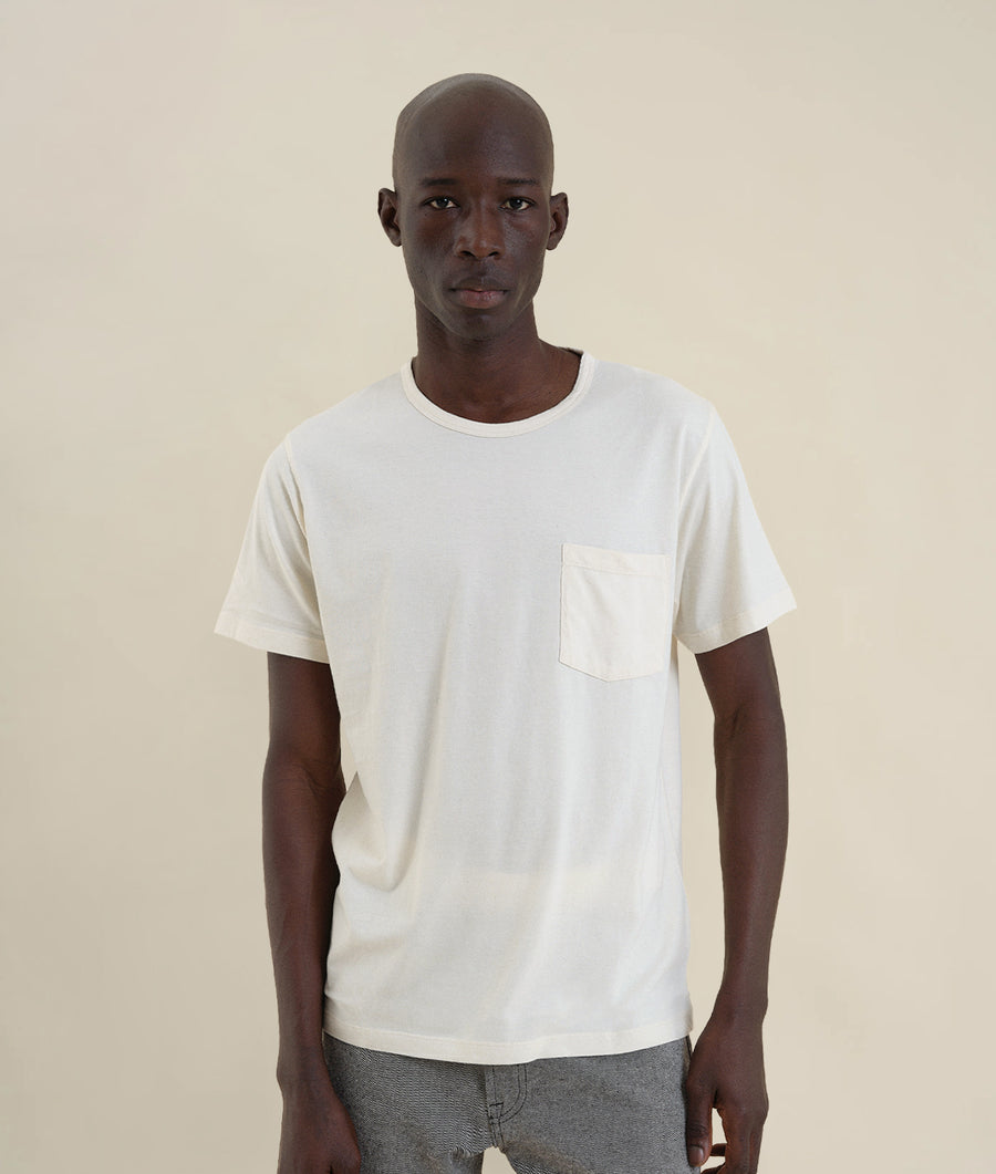 White t-shirt worn by a male model with a neutral expression - Industry of All Nations