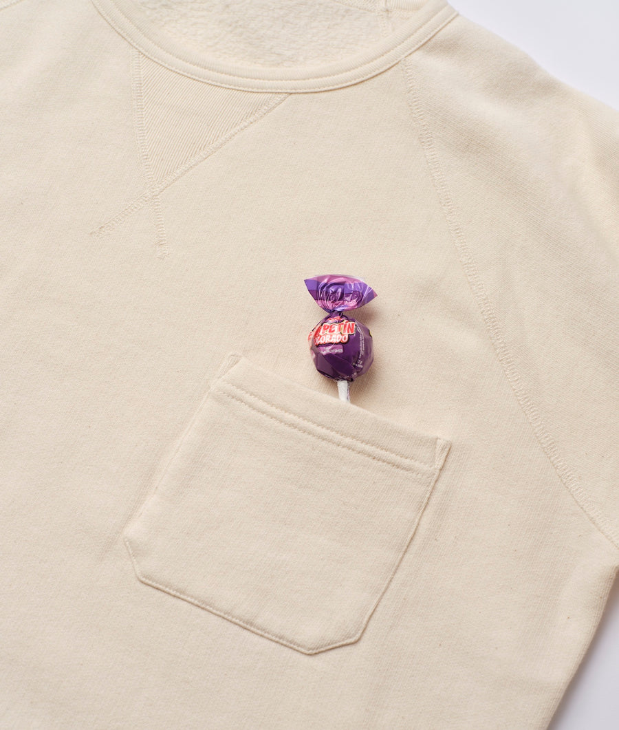 Cream-colored organic cotton sweatshirt with a purple candy-wrapped in the front pocket - Industry of All Nations