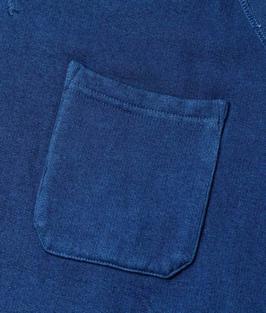 Close-up of a navy blue organic cotton pocket on an apparel item from Industry of All Nations.