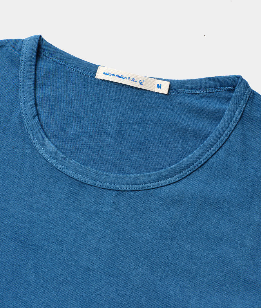 Close-up detail shot of a blue natural indigo dyed t-shirt with a size tag - Industry of All Nations