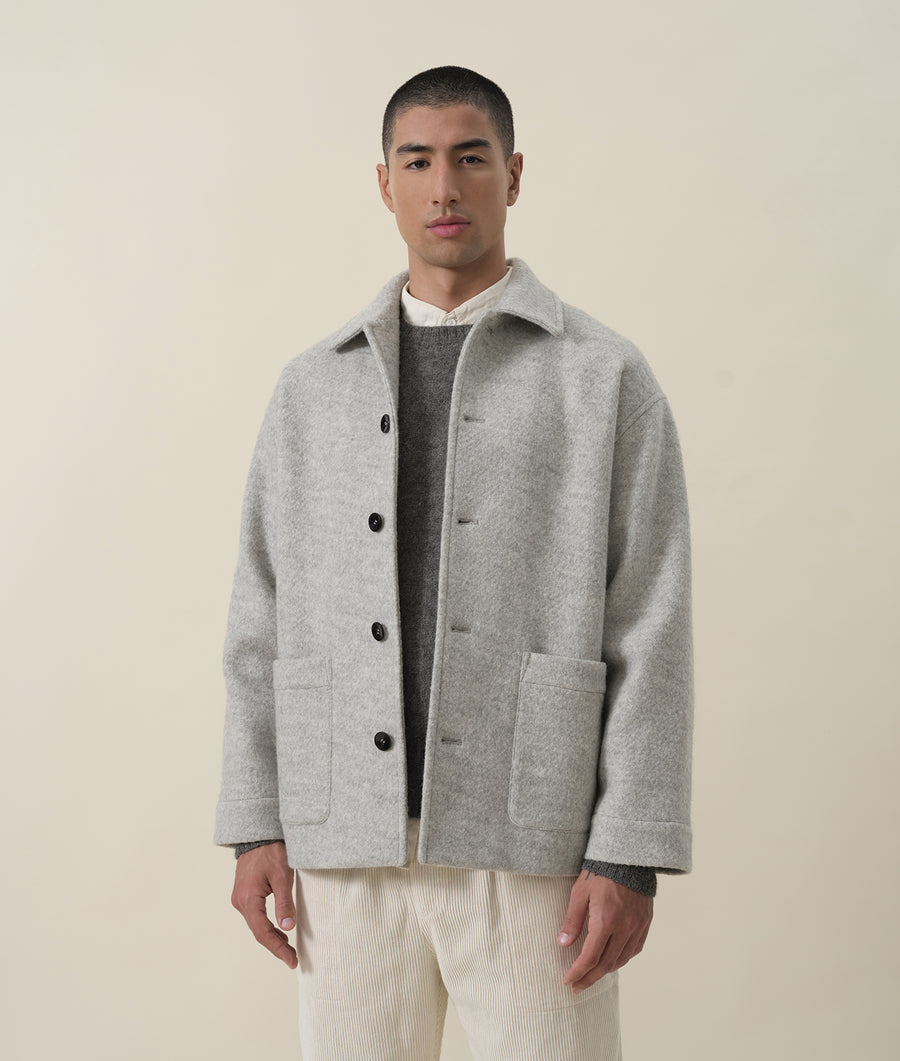 A grey woollen jacket worn by a male model, displaying the brand's minimalist aesthetic - Industry of All Nations