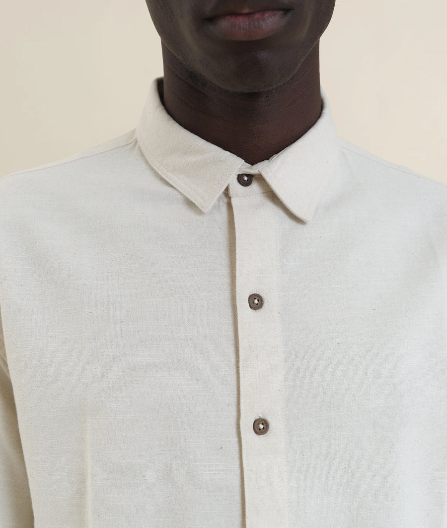 White button-down shirt worn by a model, displaying the clean, minimalist design of the garment - Industry of All Nations