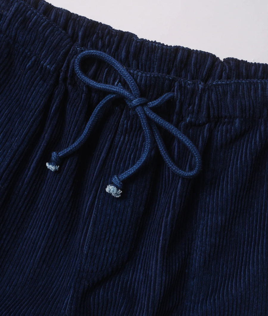 Detail shot of a navy blue pleated skirt with drawstring waist - Industry of All Nations