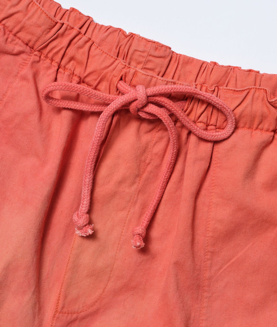 A close-up detail shot of a pair of bright coral red drawstring shorts with a braided cord tie - Industry of All Nations