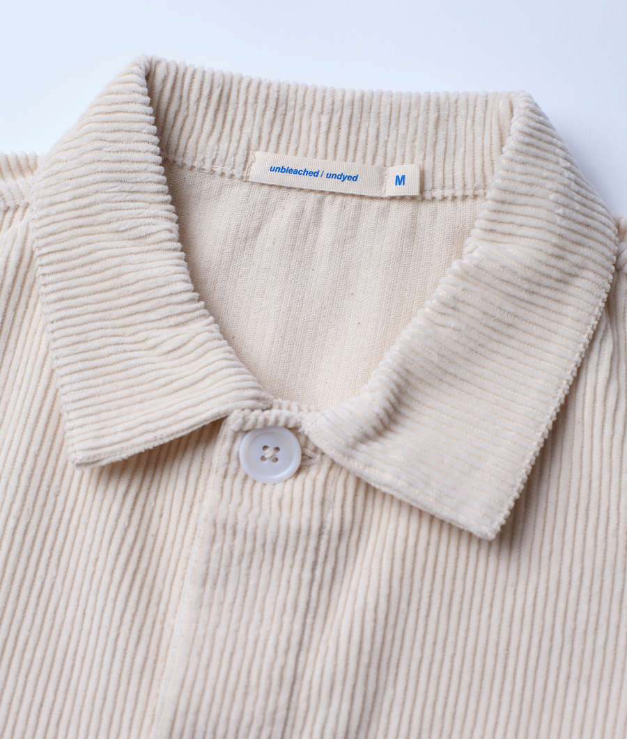 Beige corduroy shirt with M size label, displayed in a close-up detail shot - Industry of All Nations